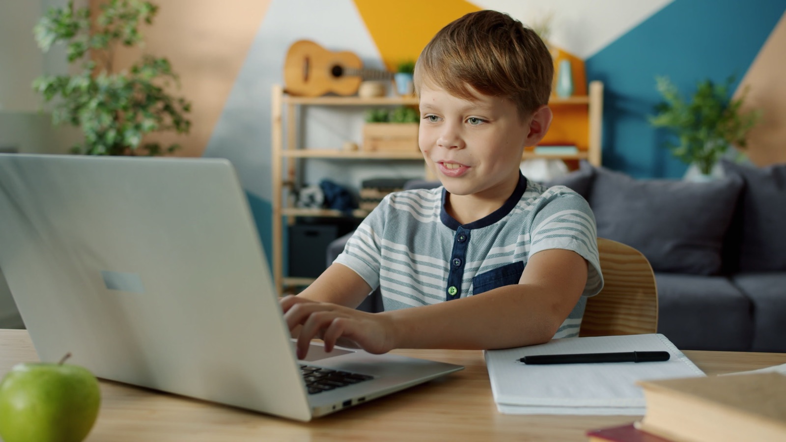 Un niño hablando con su portátil durante una clase online